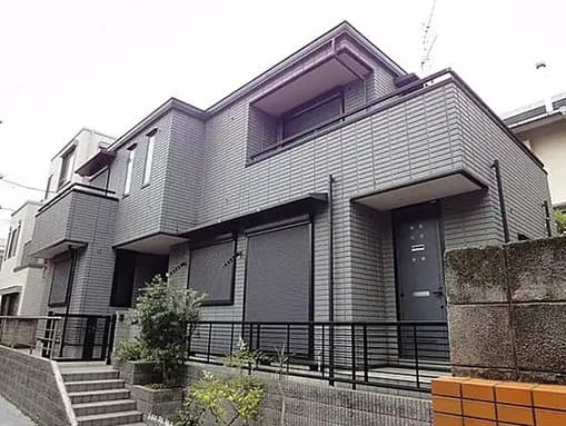 - シンプルでモダンな外観の住宅、グレーのタイル張り壁、ベランダと手すりのデザインが特徴的な二階建て 집