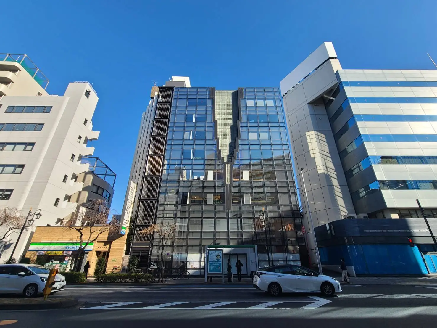 画像:晴れた日の都会的なストリートビュー、現代的な建物と青空