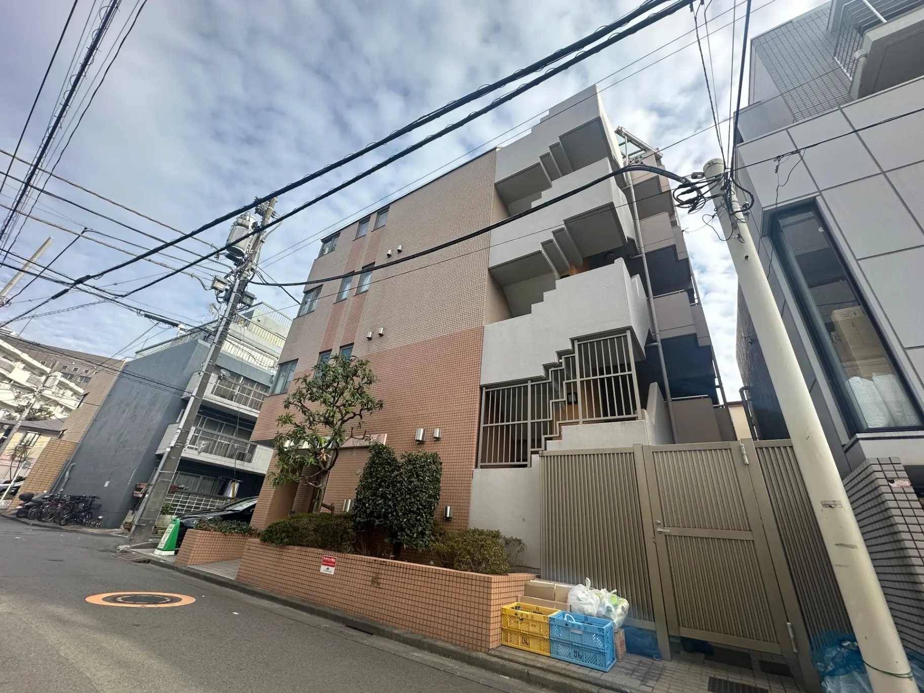 日本の都市部にあるモダンなアパートの外観、晴れた日に撮影、電線が交差する景観