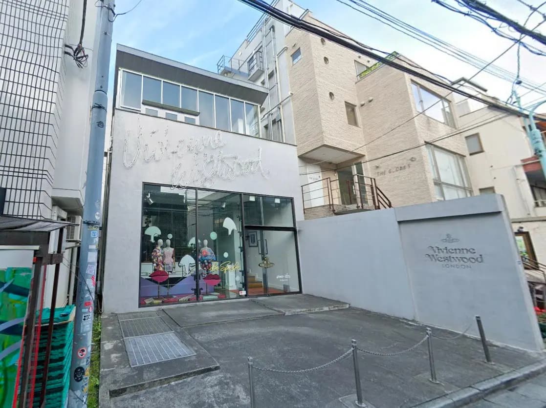- ヴィヴィアン・ウエストウッドの店舗外観、モダンなデザインの建物と大きなガラス窓、エントランスとサインが特徴的なファッションブティック