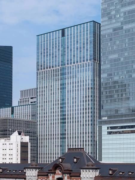 都会的な高層ビル群と歴史的な建物が混在する風景、ガラス張りの超高層ビルと伝統的な屋根の対比を収めた都市景観の写真