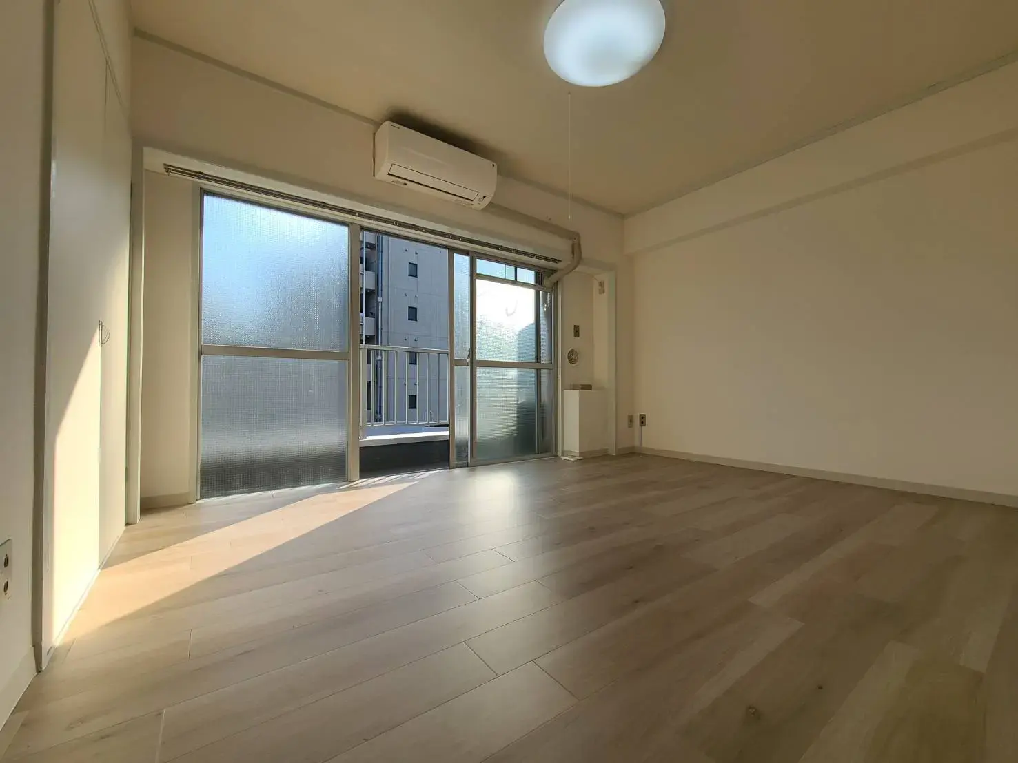 日差しが入る明るいリビングとバルコニー付きの部屋