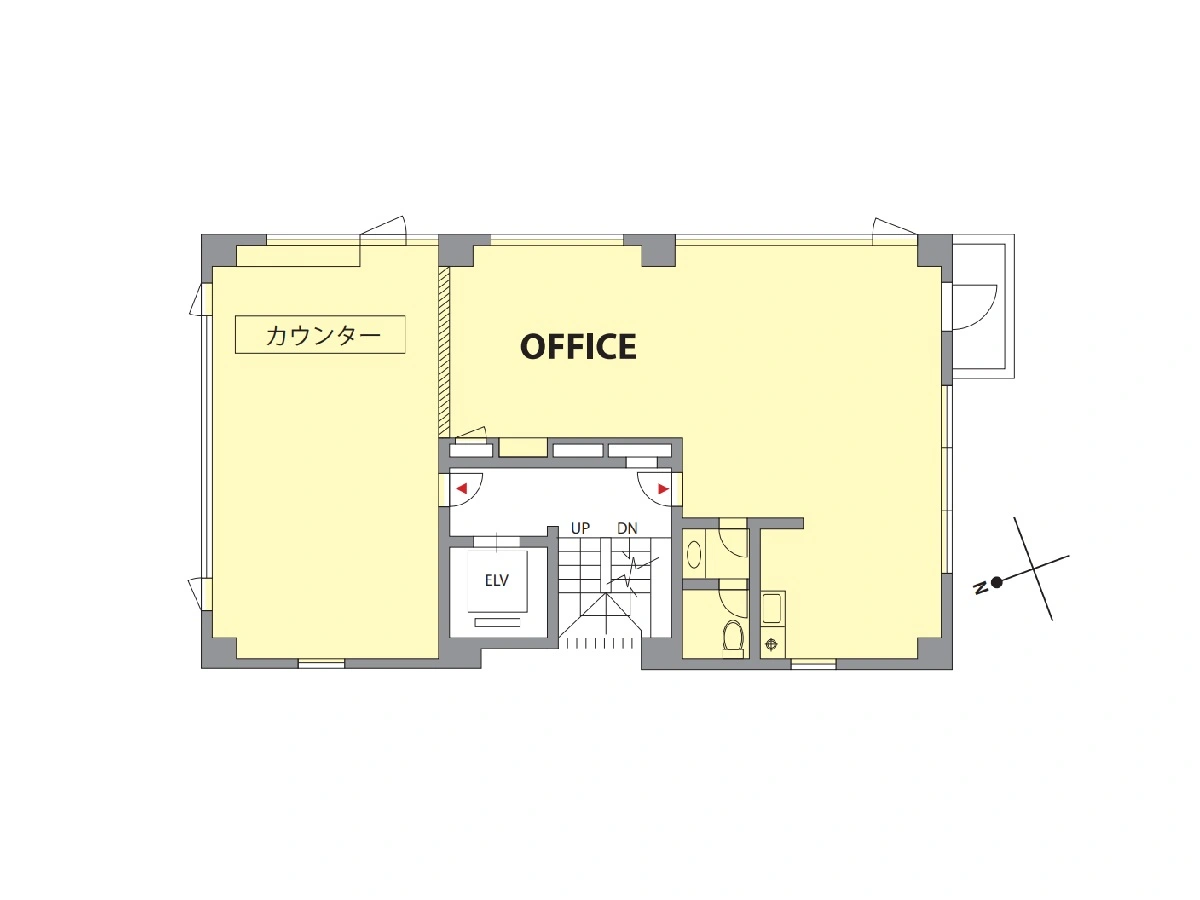 - オフィスの間取り図、中央に階段とエレベーター、左奥にカウンター付きの区画、右手に入り口と個室風の設備、広々とした作業スペースが特徴の平面図